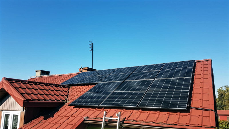 Widok na nowoczesną instalację paneli fotowoltaicznych na dachu skośnym domu jednorodzinnego w Płocku, wykonaną przez monterów SOLAND, dostarczającą ekologiczną energię i oszczędności dla gospodarstwa domowego.