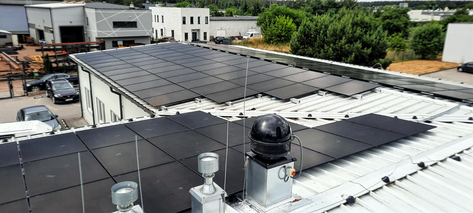 Zdjęcie widoku z góry systemu fotowoltaicznego zainstalowanego przez SOLAND na dachu firmy w Płocku, ilustrujące profesjonalizm i precyzję montażu, oraz zaangażowanie w dostarczanie zrównoważonych rozwiązań energetycznych dla biznesu.